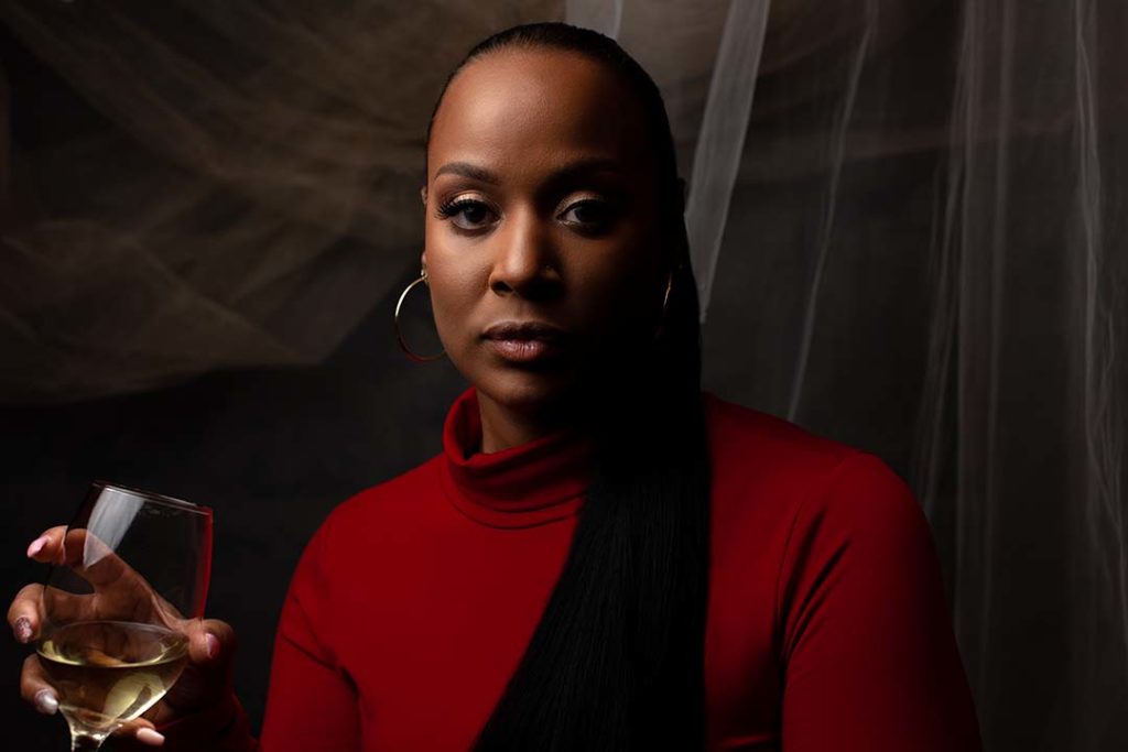 Black female holding a glass of champagne