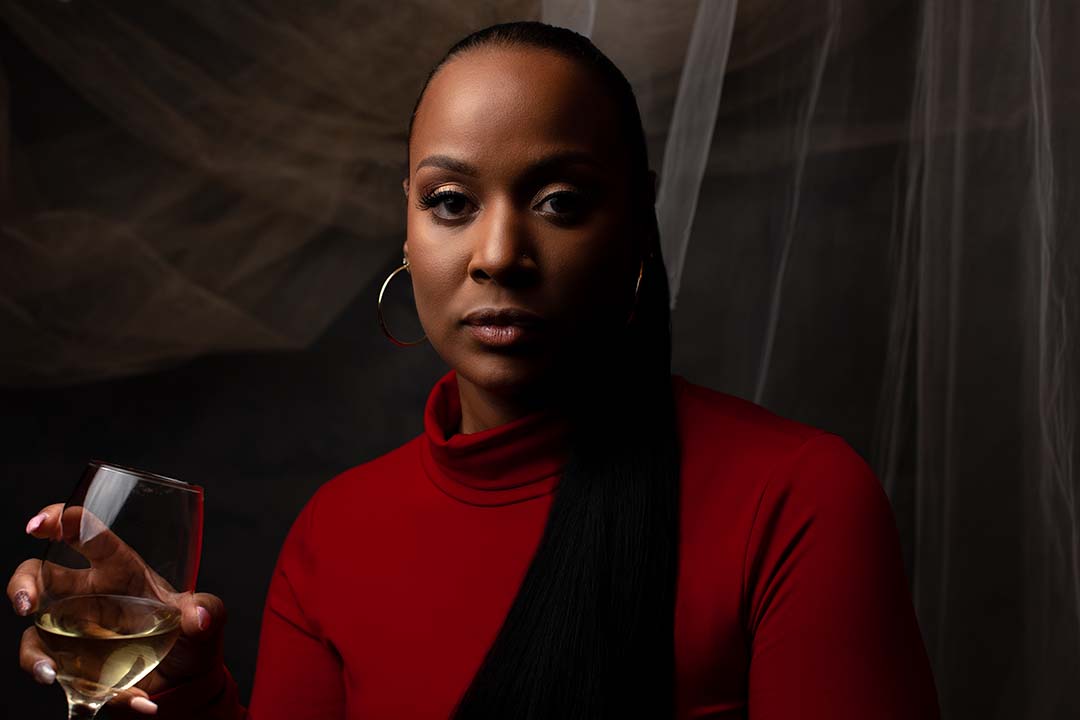 Black female holding a glass of champagne